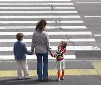 Family of three at highway crossing 
