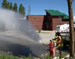 Woman releasing/flushing water from fire hydrant
